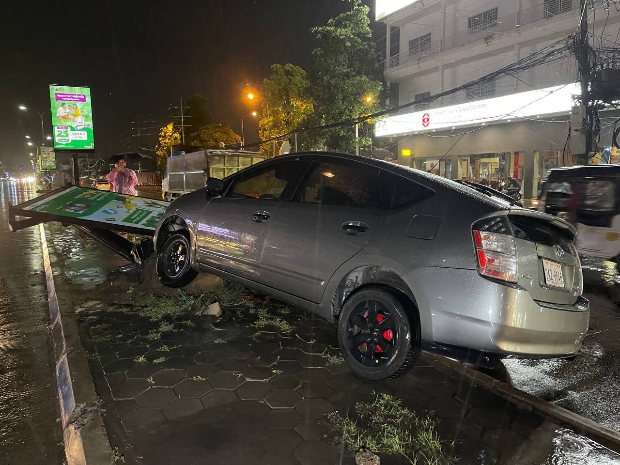 បុរសម្នាក់រថយន្តម៉ាក់Toyota Prius មួយគ្រឿងបើកលឿនដូចហោះក៏រេចង្កូតឡើងលើខឿនទ្រូងផ្លូវទៅបុកបង្គោលស្លាកសញ្ញាបាក់អស់មួយដើម